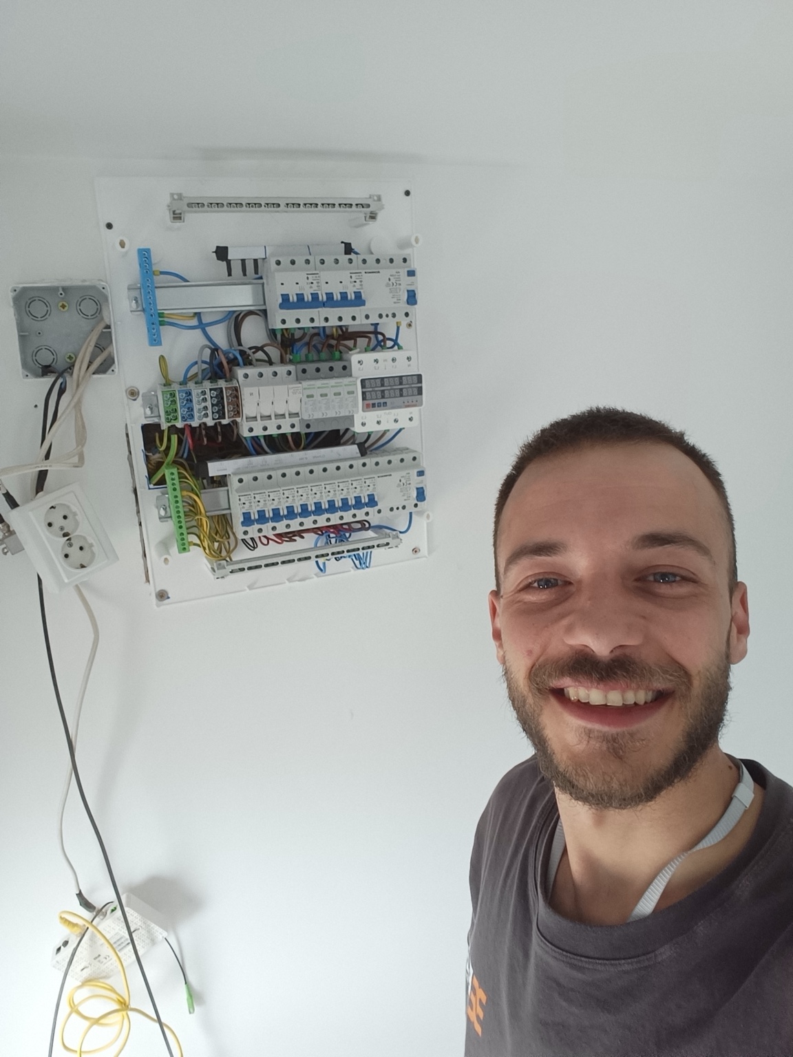 Robert alături de un tablou electric la lucru